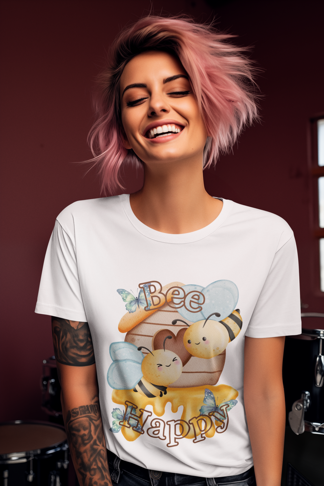Woman wearing a white t-shirt with a bee-themed design, smiling against a dark background.
